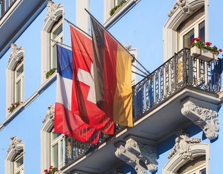 Basel, Switzerland - 27 August, 2016: balcony of the Grand Hotel Euler building decorated with flags of France, Germany and Switzerland. Basel is a city in Switzerland, located where borders of France, Germany and Switzerland meet.のeditorial素材