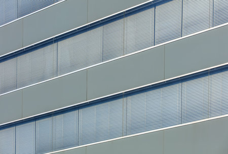 Wall of an office building with windows with closed shutters.