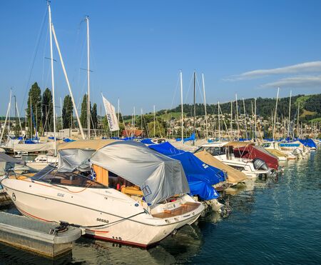 Zug, Switzerland - 14 July, 2015: boats at a pier on Lake Zug. The city of Zug is the capital of the Swiss Canton of Zug, Lake Zug is a lake in central Switzerland, situated between Lake Lucerne and Lake Zurich.のeditorial素材