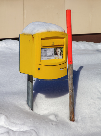 Engelberg, Switzerland - 9 March, 2016: a Swiss Post box covered by snow. Swiss Post is the national postal service of Switzerland, being a public company, headquartered in the Swiss city of Bern.のeditorial素材