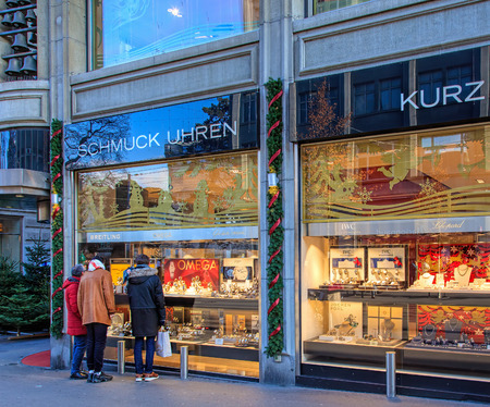 Zurich, Switzerland - 19 December, 2016: people looking at windows of the Kurz store on Bahnhofstrasse street, decorated for Christmas. Bahnhofstrasse is Zurich's main downtown street and one of the world's most expensive and exclusive shopping avenues.のeditorial素材