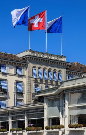 Zurich, Switzerland - 20 April, 2016: upper part of the Baur au Lac Hotel building decorated with flags of Zurich and Switzerland, view from Am Schanzengraben embankment. The Baur au Lac Hotel is a luxury hotel in Zurich, founded in 1844 by Johannes Baur.のeditorial素材