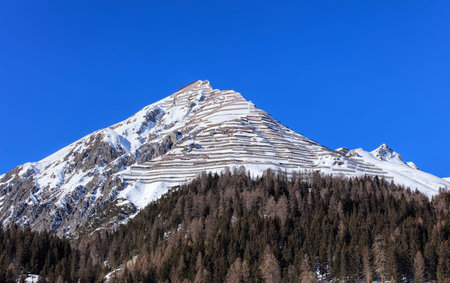 Summit of Schiahorn mountain with snow fences for avalanche control, as seen from the town of Davos...