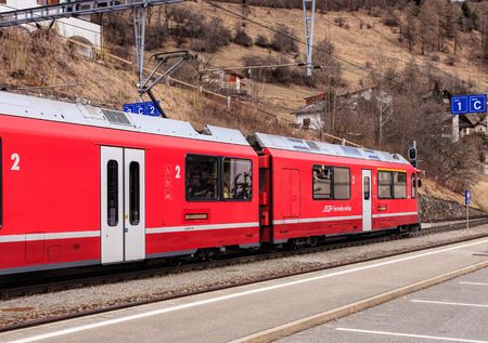 Filisur, Switzerland - 3 March, 2017: a train of the Rhaetian Railway heading to the town of St. Moritz leaving the Filisur railway station. The Rhaetian Railway (Italian: Ferrovia Retica, German: Rhatische Bahn, abbreviated as RhB), is a Swiss transport のeditorial素材