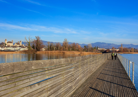Rapperswil, Switzerland - 30 November, 2016: wooden pedestrian bridge over Lake Zurich between the town of Rapperswil and the village of Hurden - the longest wooden bridge in Switzerland.のeditorial素材