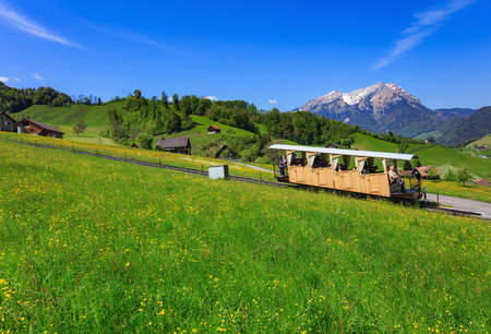 Stans, Switzerland - 8 May, 2016: people in a railroad car of the Stanserhornbahn funicular railway on Mt. Stanserhorn,  Mt. Pilatus in the background. Stanserhornbahn is a funicular railway from the town of Stans to Mt. Stanserhorn, established in 1891.のeditorial素材