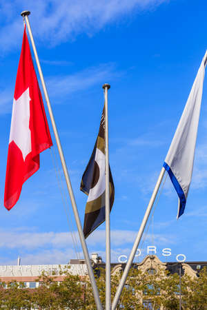 Zurich, Switzerland - 29 September, 2017: flags of Switzerland, Zurich Film Festival and Zurich canton at the venue of Zurich Film Festival on Sechselautenplatz square, blue sky and the building of the Corso cinema in the background, selective focus on thのeditorial素材