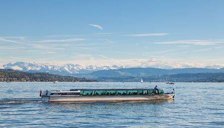 Zurich, Switzerland - 13 October, 2013: Regula boat with passengers on board on Lake Zurich, summits of the Alps in the background - view from the city of Zurich. Lake Zurich is a lake in Switzerland, extending southeast of the city of Zurich, which is thのeditorial素材