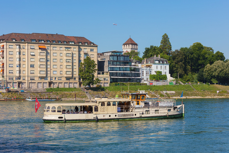 Basel, Switzerland - August 27, 2016: buildings of  the city of Basel, the Froschkonig boat with passengers on board passing along the Rhine river. Basel is a city in northwestern Switzerland, situated where the Swiss, German and French borders meet.のeditorial素材