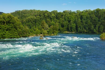 The Rhine river just above the Rhine Falls waterfall in Switzerland at the beginning of June.の写真素材