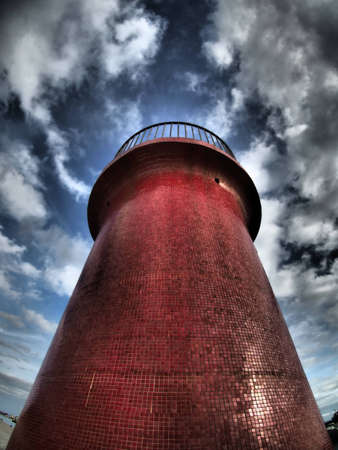 Dramatic lighthouse at dusk, harbour entrance of Castiglione della Pescaia, Maremma.の写真素材
