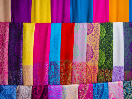 Display of colorful silk scarvers hanging on market stall, Vietnamの写真素材