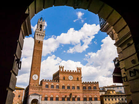 Impressive view of Siena main square (Piazza del Campo) and its most famous monuments (Palazzo Pubblico and Torre del Mangia) in a bright sunny day, Tuscany, Italyのeditorial素材