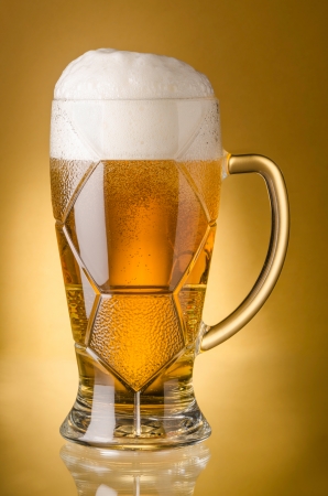 Glass of  light beerr on a yellow backgroundの写真素材