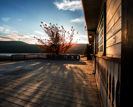 Autumn evening, negligence, beauty of autumn, rest, autumn patio with a house and tree in the sunset rays of the sunの写真素材