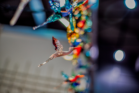 A glass stork flies against blurred multicolored background. Soft focusの写真素材