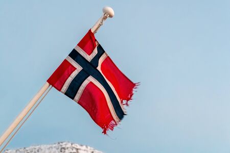 Flag of the Kingdom of Norway flutters in the wind on mast of a ship.の写真素材