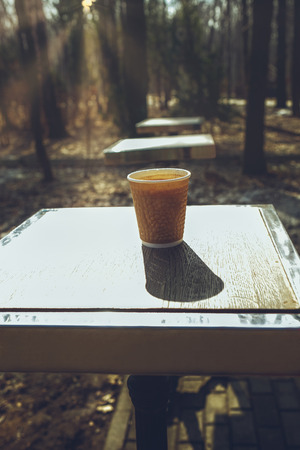 Cup of coffee on a table in a city park. Hot coffee after long walk.の写真素材