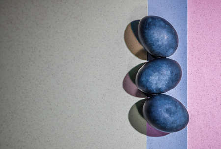 Three blue color Easter eggs on a three color background. Easter greeting card. Copy spaceの写真素材