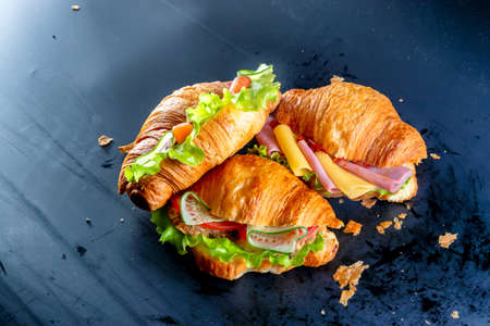 Mix of several croissants with cheese, salad, chicken, salmon, sausage and vegetablesの写真素材