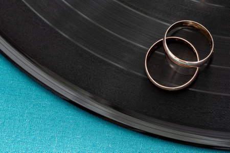 Two gold wedding rings lie on vinyl discの写真素材