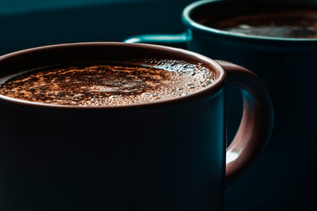Two cups of hot coffee on dark background. Shallow dof.