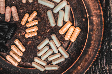 Vintage plate with medicine capsules on wooden background. Selective focus.の写真素材