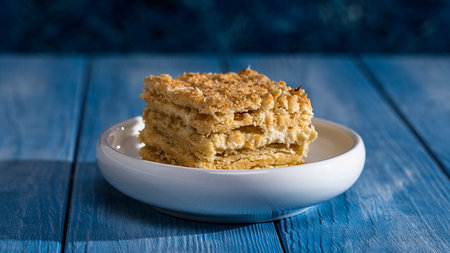 Piece of homemade cake on a blue wooden background. Selective focus.