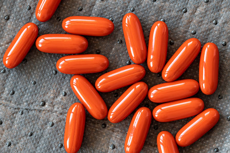 Capsules pills of red color on a gray background close-up
