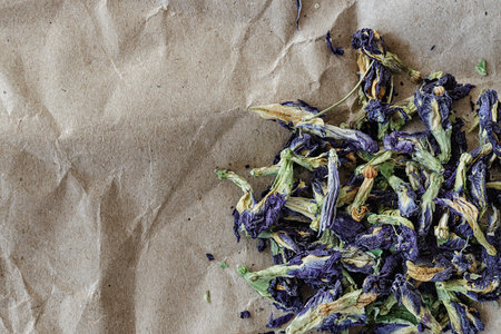selective focus topview of anchan flower herbal blue tea Clitoria Ternatea, on a sheet of kraft paper. photo with negative space.の写真素材