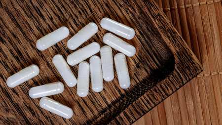 White capsules pills on a wooden background. Tablets on a wooden background.の写真素材