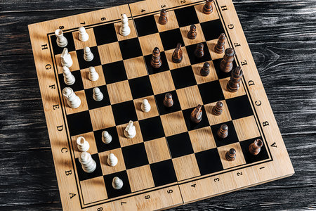 Chess board with chess pieces on dark wooden background. Top viewの写真素材