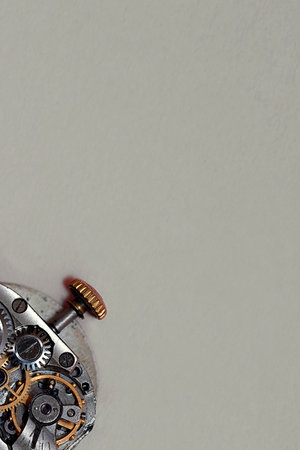 Watch mechanism with gears and cogwheels on a gray background.の写真素材