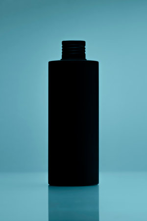 close up of a black bottle on tile blue background. cosmetic mock up. branding identity mockup concept.の写真素材
