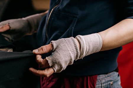 selective focus photo of male hands with t-shirt on wooden shelve on the print screening apparatus. serigraphy production. printing images on t-shirts by silkscreen method in a design studioの写真素材