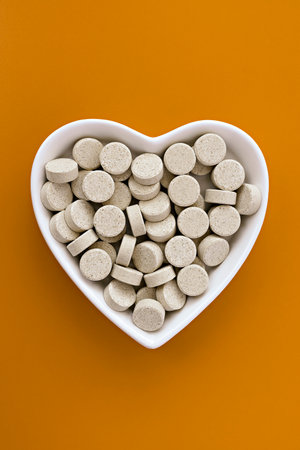 close-up of DGL (licorice root extract) chewable tablets. dietary concept: pills in the form of a heart. dietary supplement topviewの写真素材