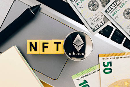 Topview photo on NFT (non-fungible token) theme. Abbreviation NFT and Ethereum blockchain cryptocurrency coin, on the background of laptop and banknotesの写真素材