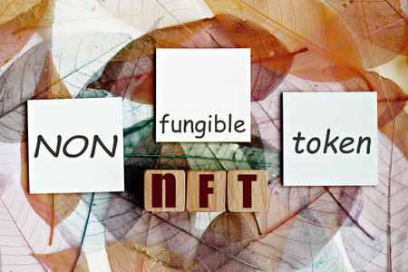 photo on nft (non-fungible token) theme. wooden cubes with the acronym "nft", and sticky notes, on the background of skeleton magnolia leafの写真素材