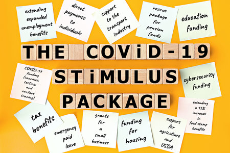 photo on The COVID-19 Stimulus Package theme. wooden cubes with the inscription The COVID-19...