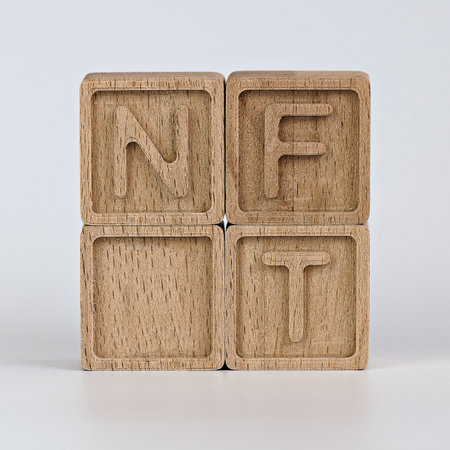 Photo on NFT (non-fungible token) theme. Wooden cubes with the abbreviation NFT, on white backgroundの写真素材