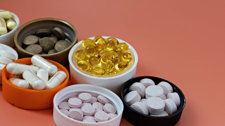 close-up of multivitamin biologically active supplements on coral background. mental wellbeing and  personal health conceptの写真素材