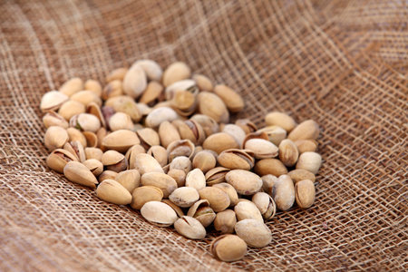 fresh pistachios useful delicious lying on the sacking background