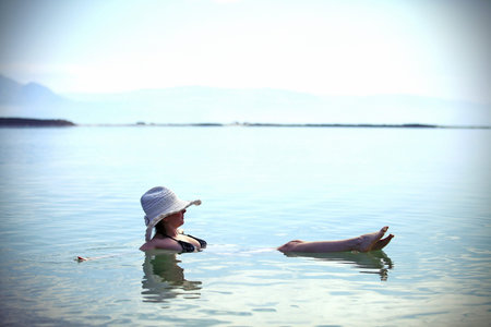 girl sunbathing on the beach with warm summer day