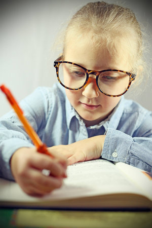 schoolgirl with big glasses makes lessons