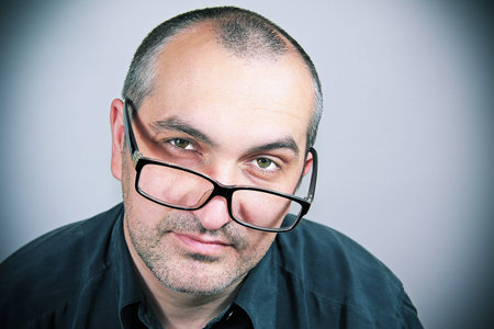 portrait of a man with glasses and a dark gray shirt