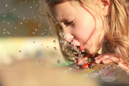 girl drinks water quenching his thirstの写真素材