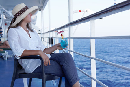 a woman in a hat and a cocktail in the summer on the liner