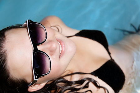 a girl in glasses relaxes the summer sea