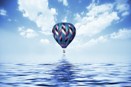 balloon flying low over the waterの写真素材