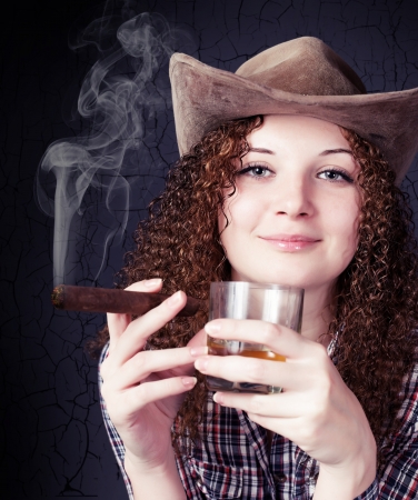 pretty curly girl in a cowboy hat with a cigarの写真素材